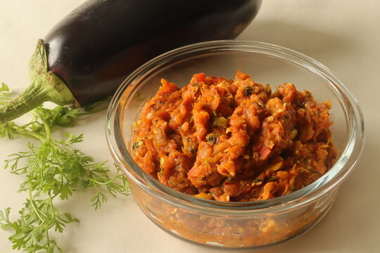 A fire roasted brinjal dish with onions tomatoes and spices. Commonly known in Indian as Baingan bharta