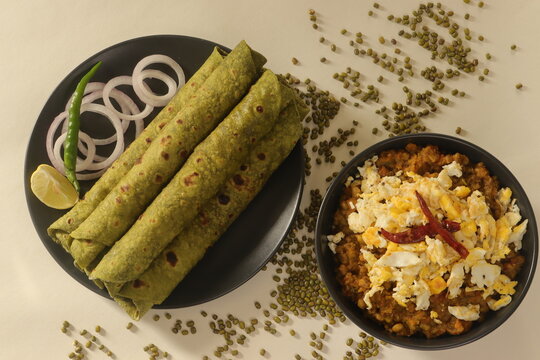 Indian flatbread made with whole wheat flour kneaded with pureed spinach and spices. Served with Green moong beans gravy with scrambled egg on top.