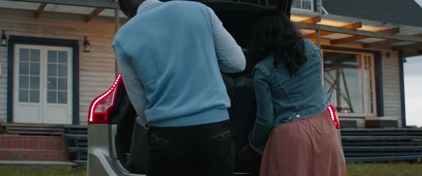 TRACKING Happy African American family of arriving by car to their new house. Shot with 2x anamorphic lens