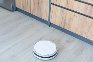 Smart House. Vacuum cleaner robot runs on wood floor in a living room