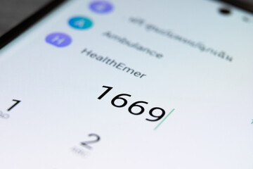 Phone dialing 1669 COVID-19 emergency number in Thailand used to call ambulance for hospital...