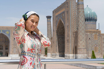 Muslim girl puts a scarf on her head - obrazy, fototapety, plakaty