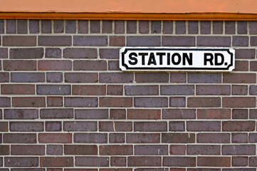 Obraz premium Station Road nameplate attached to a brick wall. No people.