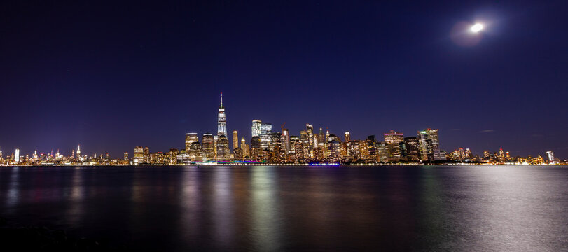 A panorama picture of Manhattan skyline at night with One World Trade Center