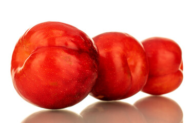 Several juicy sweet, red plums, close-up, isolated on white.