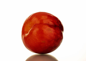 One juicy sweet, red plum, close-up, isolated on white.