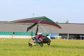 Ultralight airplane taking off from a grass airfield	