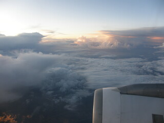 An airplane jet engine and cloudy sky and sunset colors