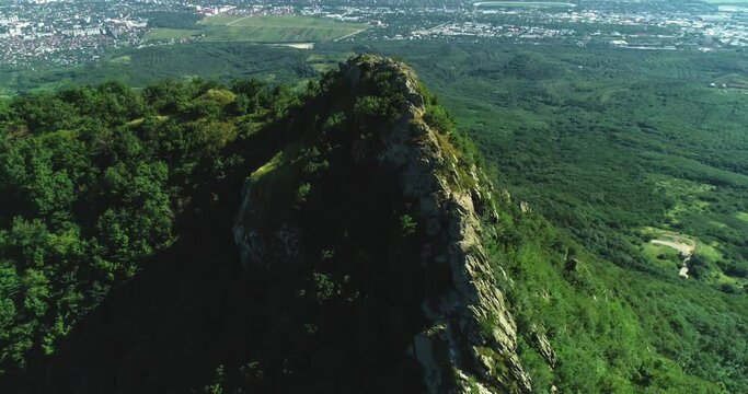 Aerial view of picturesque cliffs and green mountain slopes outside the city. Landscape and nature of the North Caucasus.
