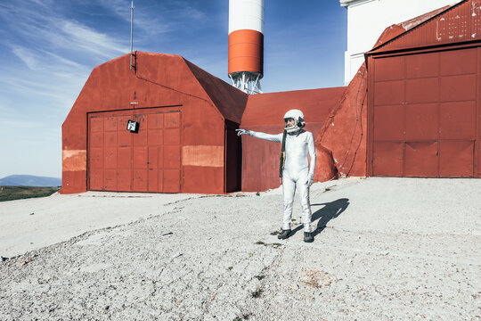 Astronaut standing outside industrial building