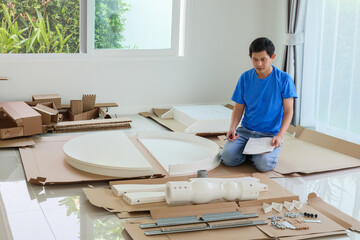 Man assembling white round table furniture at home