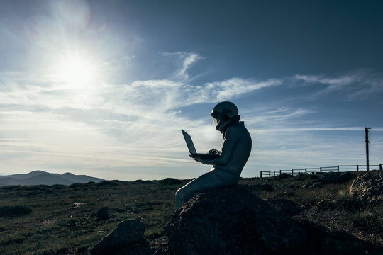 Cosmonaut using laptop near base