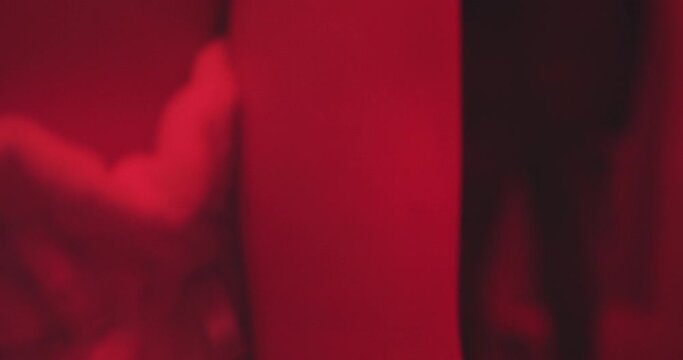 Unidentified woman in towel with gun points the gun at man in a photo dark room. Red Room, Silencer, Stylistic spy movie or film noir. (Shot on RED) 4K
