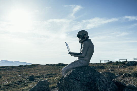 Cosmonaut using laptop near base