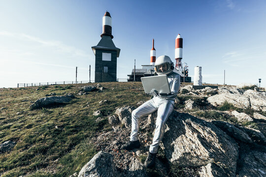 Cosmonaut using laptop near base