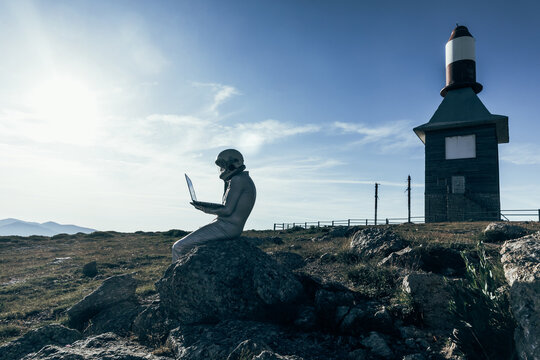 Cosmonaut using laptop near base