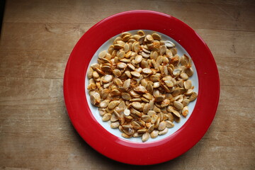 Kürbiskerne mit Schale auf rotem Teller