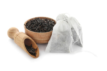Tea bags and bowl with dry leaves on white background