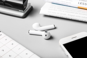 Modern earphones on grey background, closeup