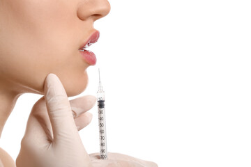 Young woman receiving filler injection in lips against white background, closeup
