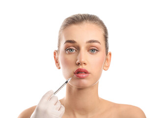 Fototapeta premium Young woman receiving filler injection in lips against white background
