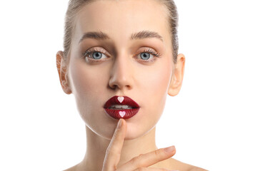 Beautiful young woman with hearts on lips against white background