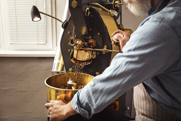 Senior man using modern coffee roaster