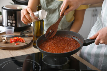 Young couple preparing rice in kitchen