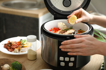 Woman squeezing lemon onto fish in multi cooker