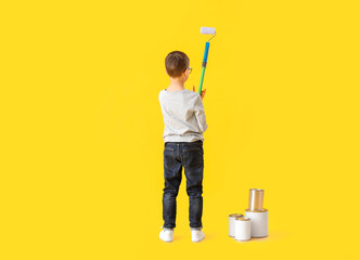 Cute little boy with paint roller on color background