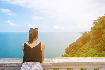 Young caucasian woman in black top overlooking the Sea and Forest. Copy space. Top View from Botanical Garden in Batumi, Adjara Georgia. Summer day. Vacation concept.