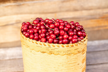 ripe sweet red cherry in a basket on a wooden background