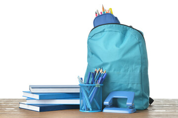 School backpack and stationery on wooden table against white background