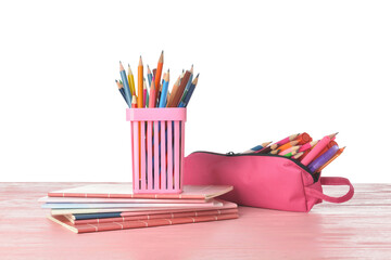 Holder and case with pencils on color wooden table against white background