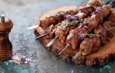 Shish kebab, Grilled lamb meat skewers with spices and oregano flowers on a wooden board, selective...