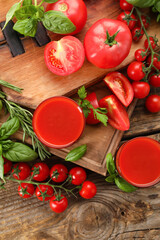 Glasses of tasty tomato juice on wooden background