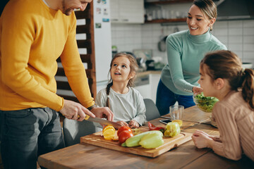 Young happy family prepares healthy food in the kitchen.