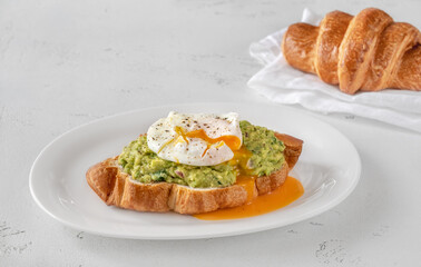 Croissant with guacamole and poached egg