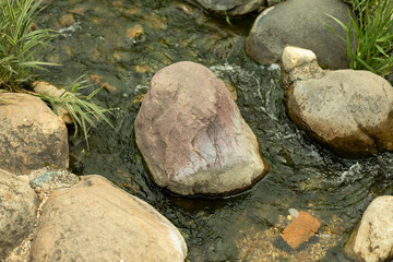 Water runs over the stones. Fresh water stream.