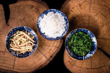 Shirataki rice or noodles, shimeji mushrooms and wakame in bowl on wooden table background. Konnyaku from konjac yam. Healthy japanese diet. Gluten and carbs free KETO food. Traditional oriental style