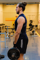 Fototapeta premium young brazilian man lifting weights with a weighted barbell in a gymnasium