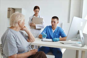 Obraz premium an elderly woman communicates with a nurse and a doctor in a hospital diagnostics