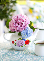 purple and pink hydrangea flowers in the teapot