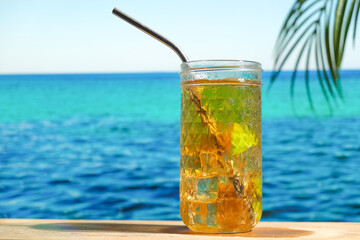 Summer cocktails, sea resort concept. Glass of iced tea. Long island cocktail on tropical beach.