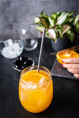 Freshly squeezed orange juice with ice and an orange slice. Refreshing drink with vitamin C