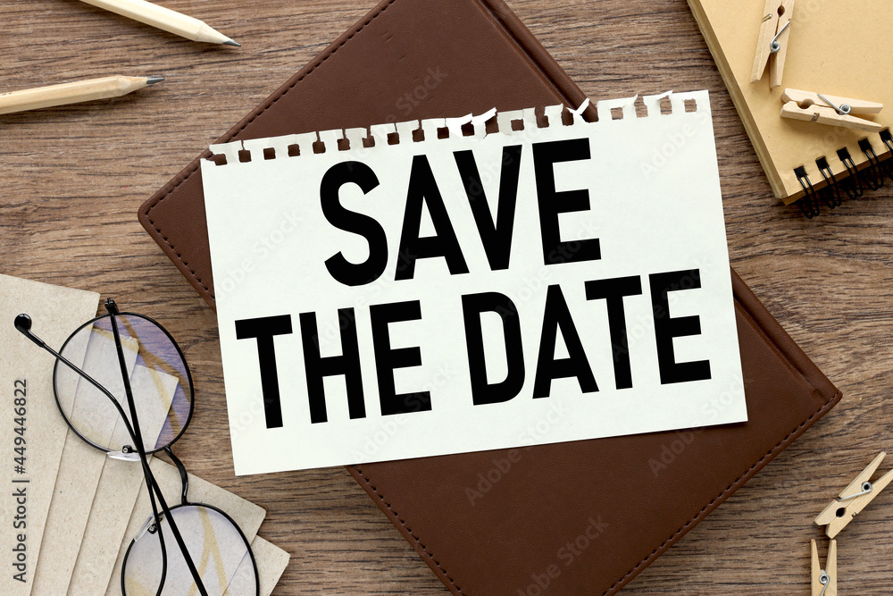 Poster save the date. notebook on a wooden table