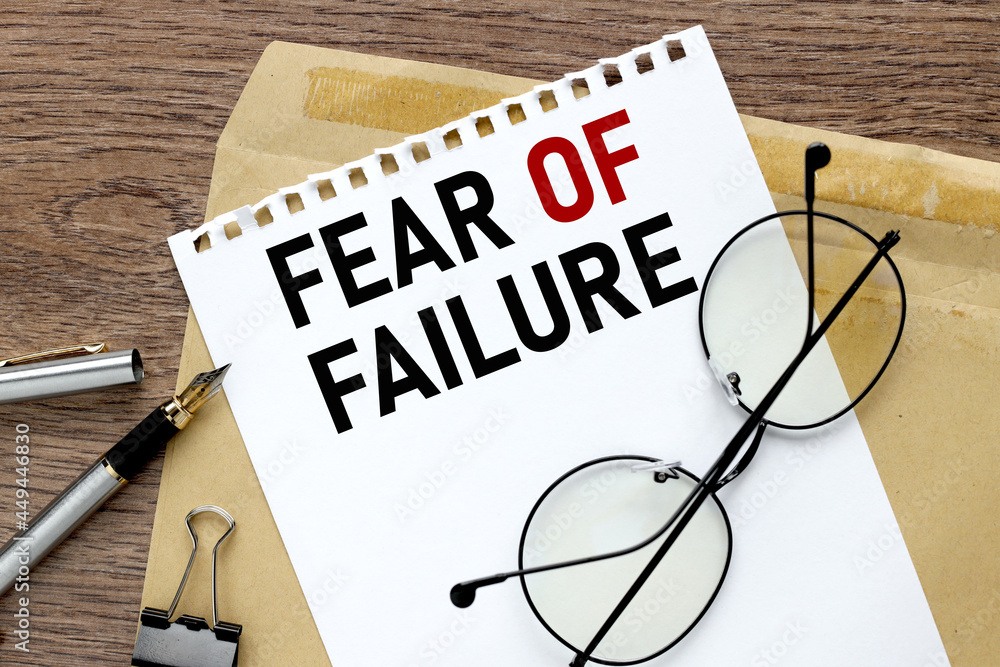 Poster fear of failure. craft notebook on wood table with text on paper and pen