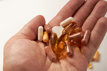 Different types of pills and tablets on pink background