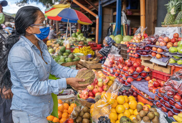 Fototapeta na wymiar latin woman buying fruit in market. Woman in central american market