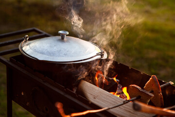 Cooking in a pot on the fire. Camping concept.